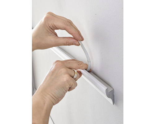 Anbringen einer Zierleiste an der Wand mit Klebeband