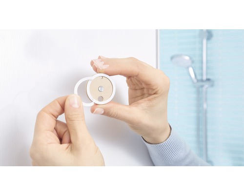 Person montiert ein Bad-Accessoire an der Wand