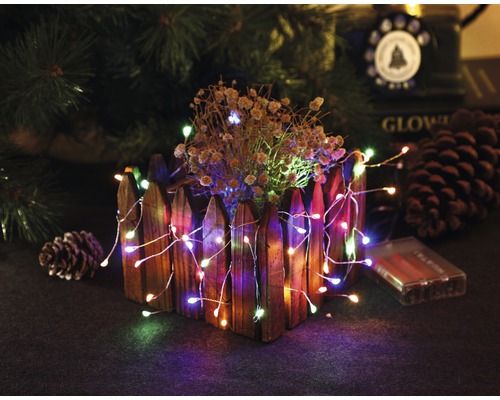 Dekorative Lichterkette mit Holzpflanzgefäß und Tannenzapfen