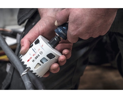 Eine Person befestigt eine Lochsäge am Bohrfutter.