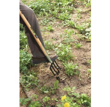 Person verwendet eine Grabgabel zur Gartenarbeit.