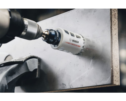 Bohrmaschine mit Bosch Lochsäge beim Bohren eines Lochs in ein Material