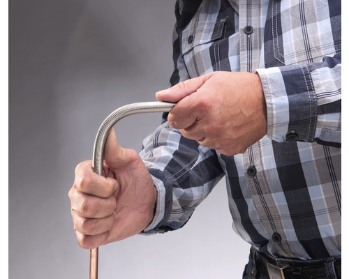 Eine Person biegt ein flexibles Metallrohr.