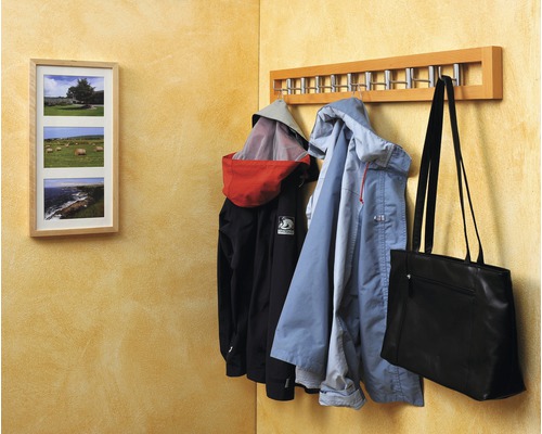 Garderobe mit Jacken und Tasche an einer Wand mit Bilderrahmen
