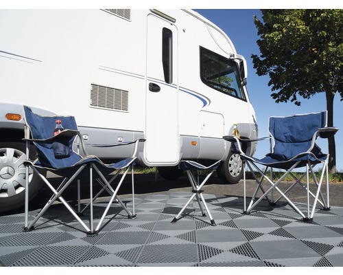 Campingplatz mit zwei Campingstühlen, Hocker und Wohnmobil auf Fliesen