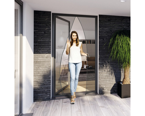 Frau geht durch eine geöffnete Insektenschutztür auf eine Terrasse.