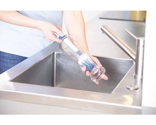 Reinigung einer Vase mit einer Spülbürste in einem Spülbecken aus Edelstahl