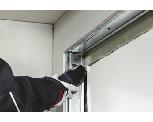 Handwerker schneidet Metallprofil mit einem Multifunktionswerkzeug in einem Trockenbau