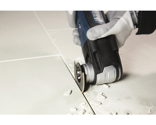 Multifunktionswerkzeug beim Bearbeiten einer Fliesenfuge