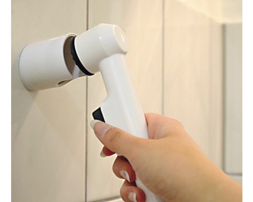 Elektrische Reinigungsbürste mit Wandhalterung in einer Hand