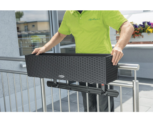 Person montiert einen schwarzen Balkonkasten mit Halterung am Geländer