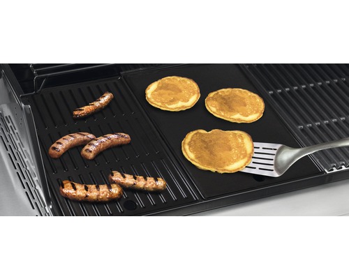 Grill mit Würstchen und Pfannkuchen auf einer Grillplatte