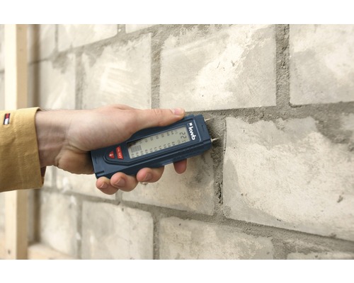 Feuchtigkeitsmessgerät im Einsatz an einer Ziegelwand
