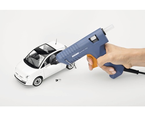 Heißklebepistole beim Kleben eines Spielzeugautos