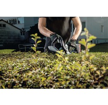 Eine Person trimmt eine Hecke mit einer Heckenschere der Marke Metabo