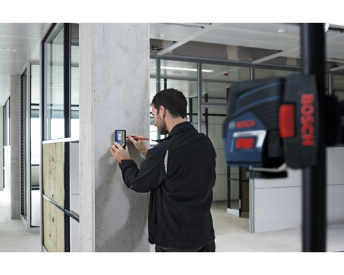 "Ein Mann benutzt ein digitales Messgerät an einer Betonwand