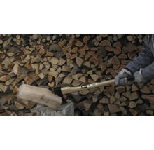 Holzspalter beim Spalten von Holz vor einem Holzhintergrund