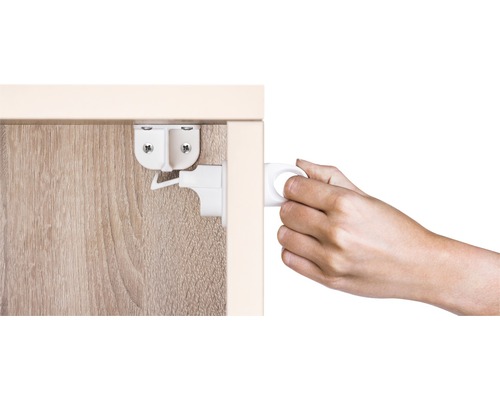 Kindersicherung an einer Schranktür befestigt und von einer Hand bedient