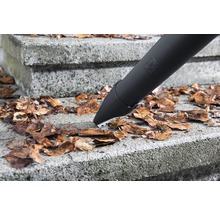 Ein Laubbläser entfernt Laub von einer Steintreppe.