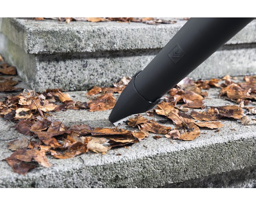 Ein Laubbläser entfernt Laub von einer Steintreppe.