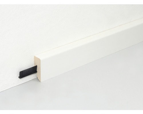 Weiß lackierte Holzfußleiste mit Befestigungsclip an Wand und Boden