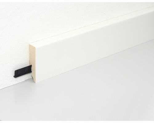 Weisse Fussleiste mit Befestigungsclip an einer Wand montiert