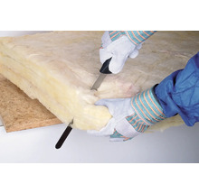 Person schneidet Mineralwolle mit einem Messer zu.