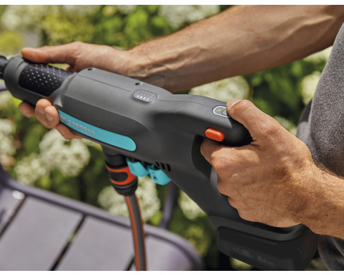 Eine Person bedient eine Gardena Gartendusche mit Akku