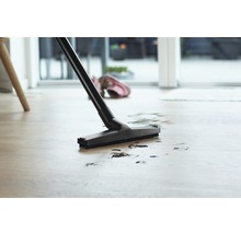 Staubsauger reinigt Schmutz auf dem Boden