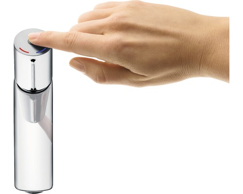 Eine Hand bedient einen Wasserhahn mit Druckknopf