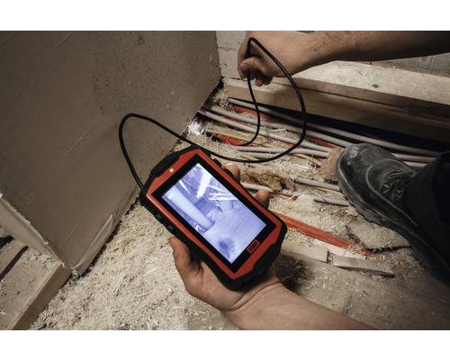 Eine Inspektionskamera mit Kabel wird verwendet, um Rohre in einem unaufgeräumten Bereich zu überprüfen.