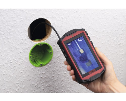 Eine Inspektionskamera wird verwendet, um in eine Wandöffnung zu schauen.