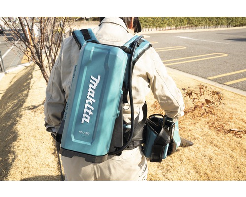 Mann mit Akku-Laubbläser von Makita auf dem Rücken bei der Gartenarbeit