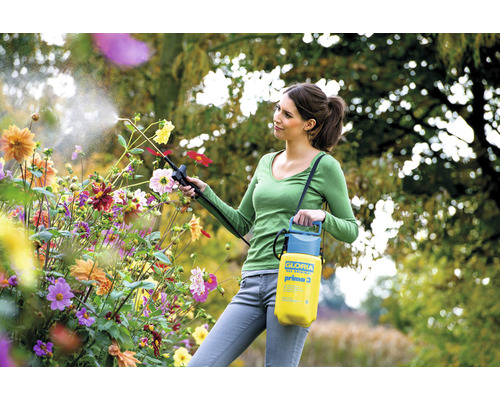 Frau verwendet eine Gloria Prima 3 Druckspritze zur Gartenarbeit