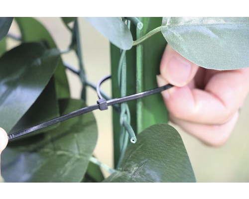 Detailaufnahme der Befestigung einer künstlichen Hecke mit einem Kabelbinder.