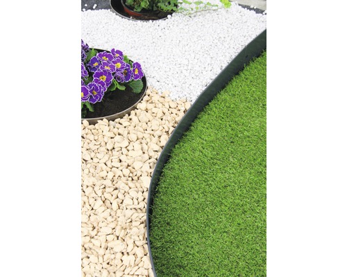 Gartenszene mit Rasen, Kies und Pflanzen in runden Beeten mit Metalleinfassung