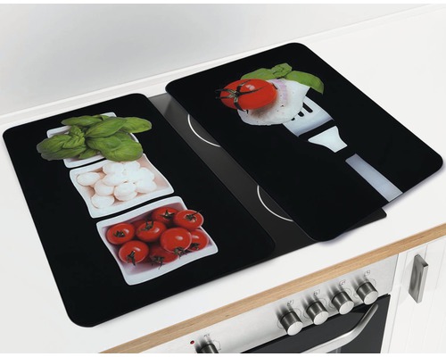 Zwei schwarze Herdabdeckplatten mit Lebensmittelmuster auf einem Herd