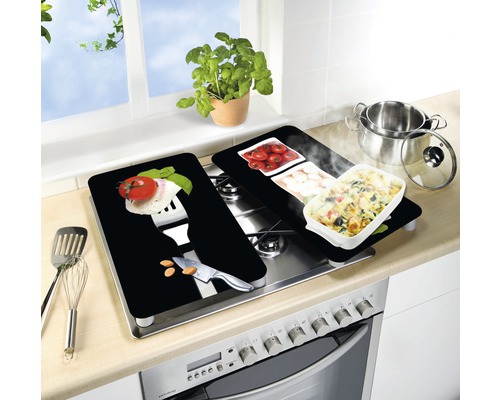 Herdabdeckplatten auf einem Herd mit Lebensmittelmuster und Kochutensilien