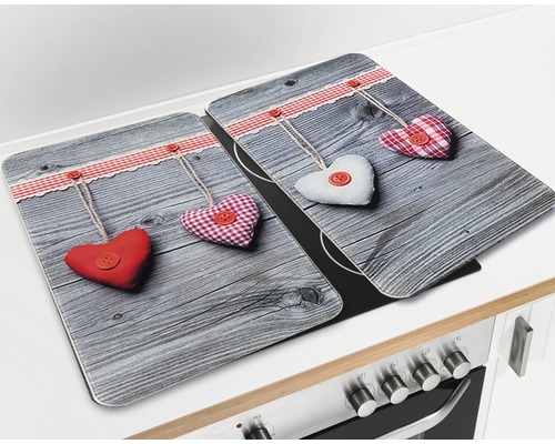 Zwei Herdabdeckplatten mit Herzmotiv liegen auf einem Herd.