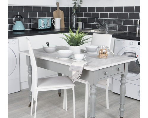 Esstisch mit Geschirr und Stühlen in einer Küche