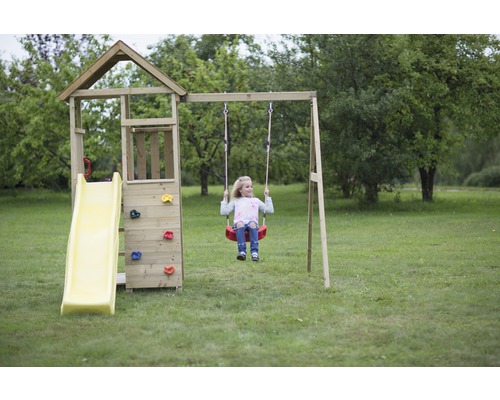 Kind auf einer Schaukel an einem Spielturm mit Rutsche und Kletterwand im Garten