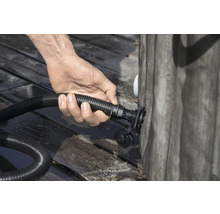 Eine Person schließt einen Schlauch an einen Pool an.