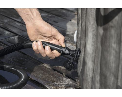 Eine Person schließt einen Schlauch an einen Pool an.