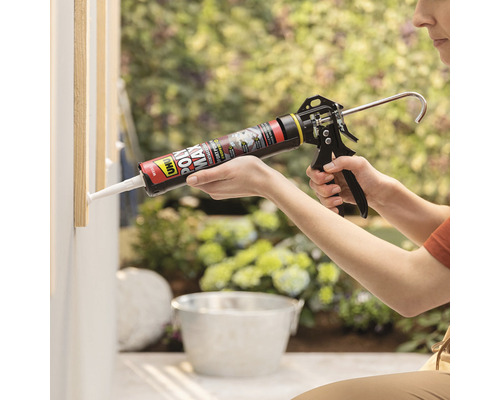 Eine Person verwendet eine Kartuschenpistole, um Dichtmasse aufzutragen