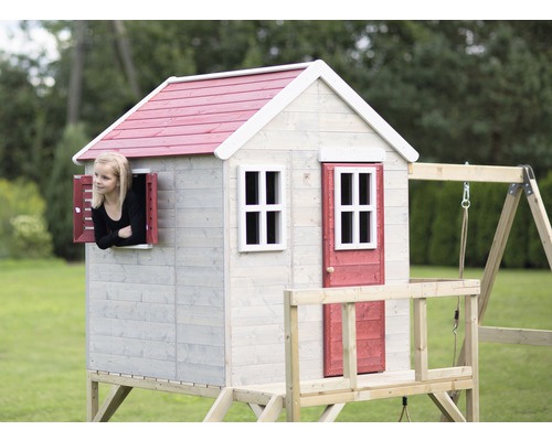 Spielhaus aus Holz mit Schaukel und blickendem Kind