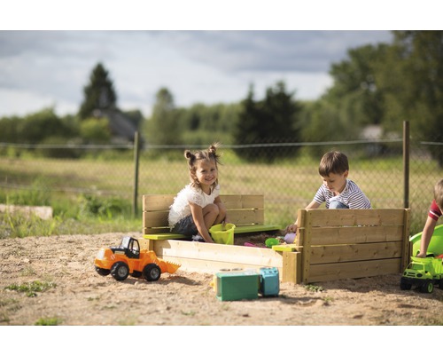 Kinder spielen in einem Sandkasten mit Spielzeug im Freien