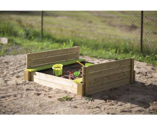Sandkasten aus Holz mit Spielzeug im Garten