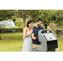 Ein Paar grillt in einem Garten mit einem Gasgrill
