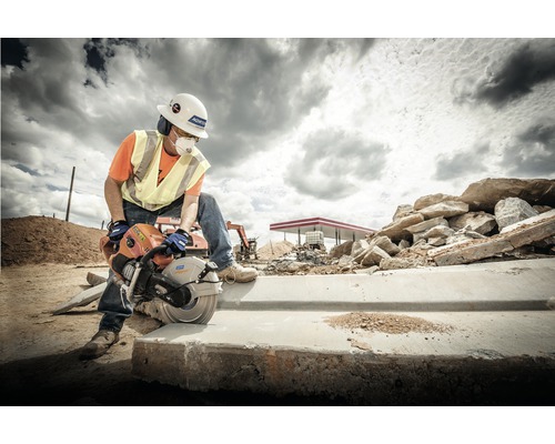 Bauarbeiter schneidet Beton mit einer Steinsäge auf einer Baustelle.