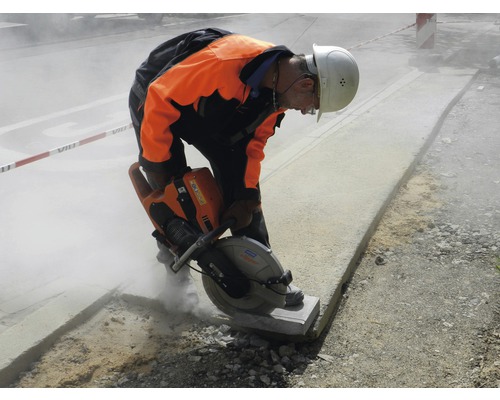 Bauarbeiter schneidet Stein mit einer Steinsäge auf einer Baustelle.